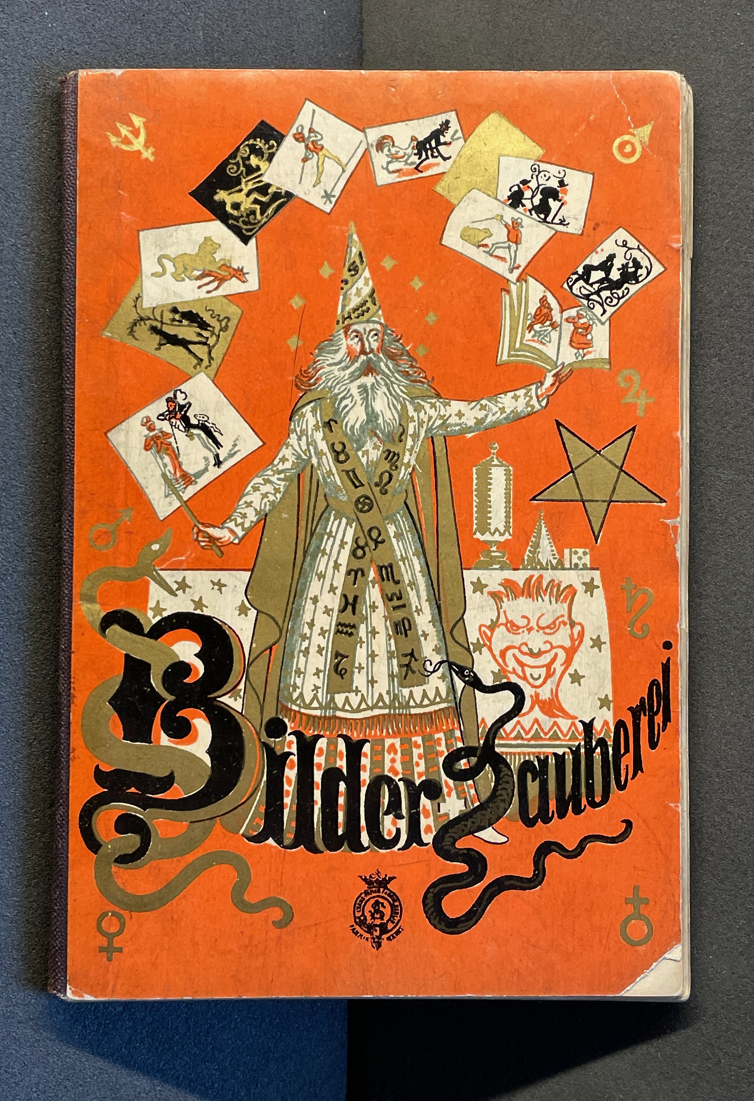 Colorful vintage book cover featuring a wizard with a long beard and pointed hat, surrounded by magical symbols and images, on an orange background.